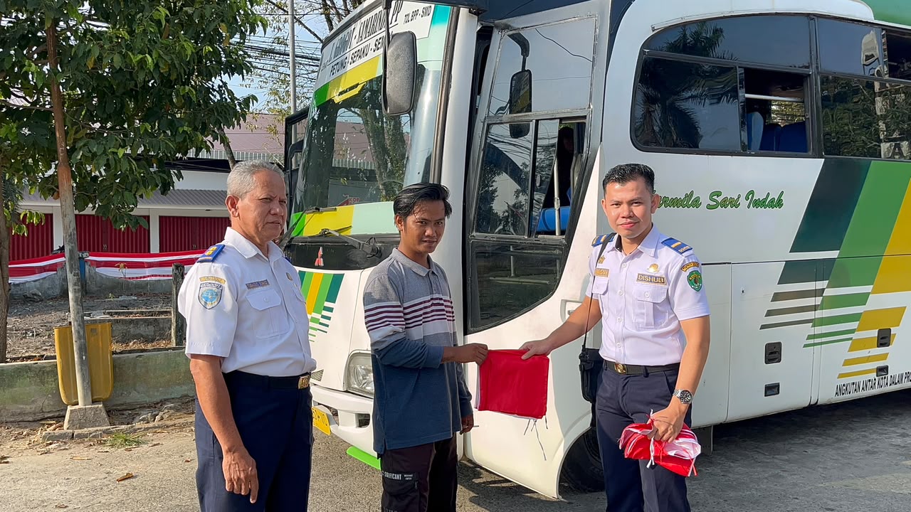 Penyerahan bendera Merah Putih kepada awak bus Angkutan Antarkota Dalam Provinsi (AKDP) di Terminal Tipe B Sungai Kunjang.