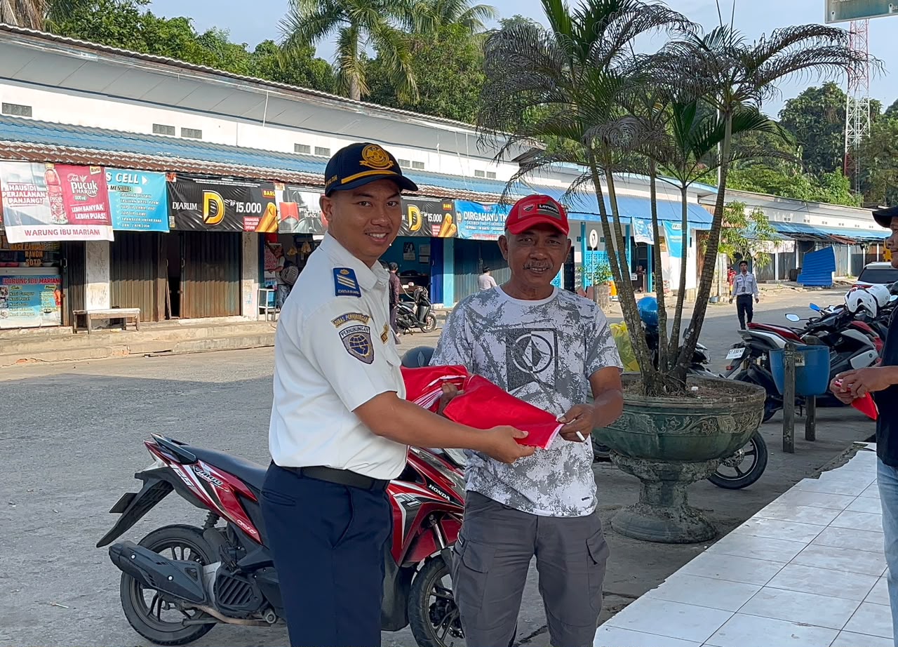 Petugas Dinas Perhubungan menyerahkan bendera Merah Putih kepada masyarakat di kawasan Terminal Tipe B Sungai Kunjang, Samarinda.